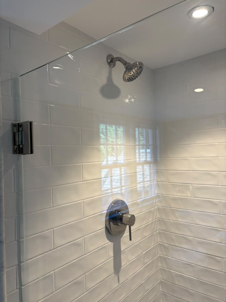 Shower with polished chrome fixtures and subway tile