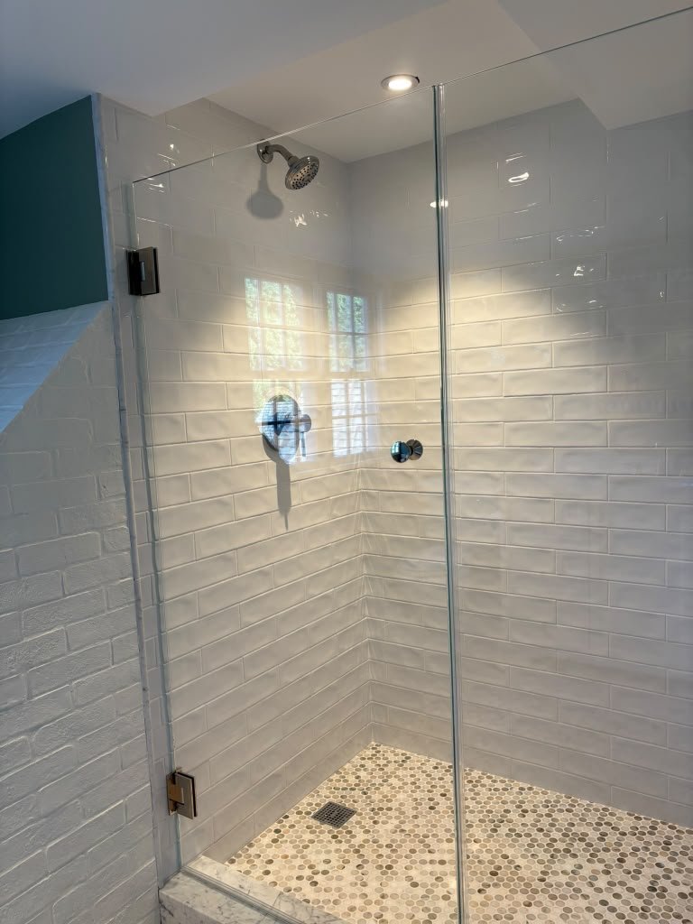 Frameless glass shower with white subway tile