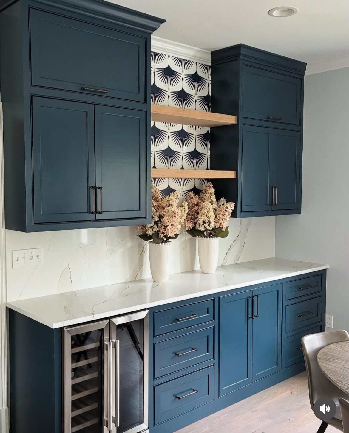Custom navy kitchen cabinetry with wine fridge and floating shelves