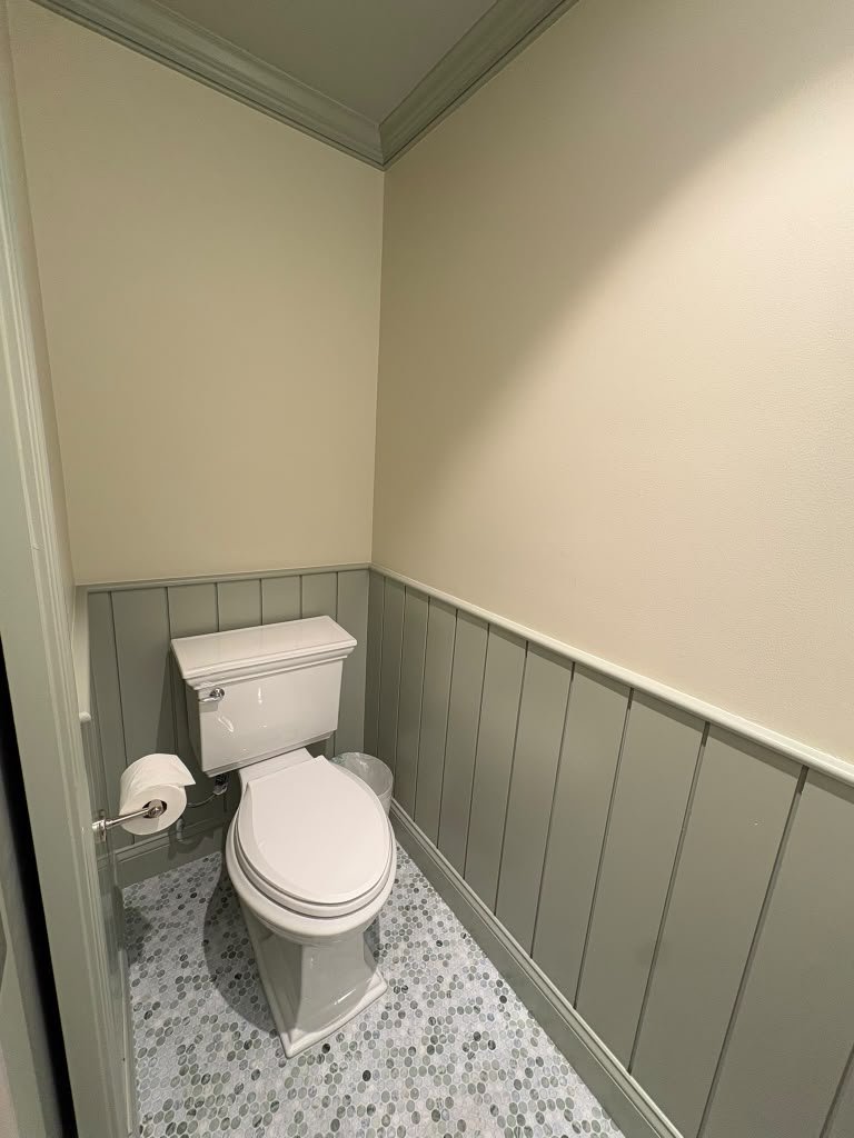 Water closet with vertical wainscot and mosaic floor